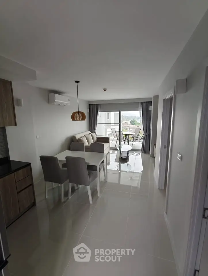 Modern open-plan living room with dining area and balcony view