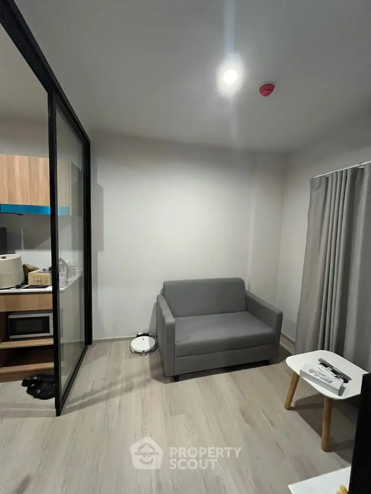 Modern compact living room with gray sofa and glass partition