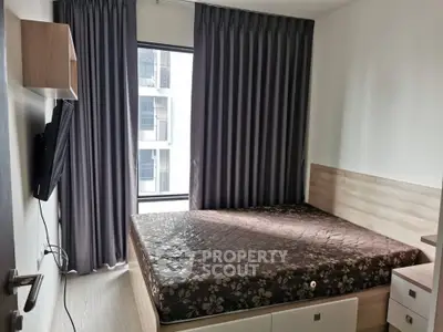 Modern bedroom with large window and stylish curtains in a contemporary apartment.