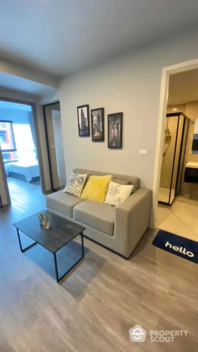 Inviting modern living room with plush sofa, chic decor, and welcoming 'hello' mat, showcasing a blend of comfort and style for urban living.