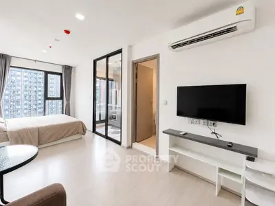 Modern studio apartment with open layout, featuring a cozy bedroom and sleek living area with city views.