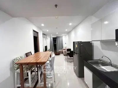 Modern open-layout kitchen and living area with sleek design and ample lighting.
