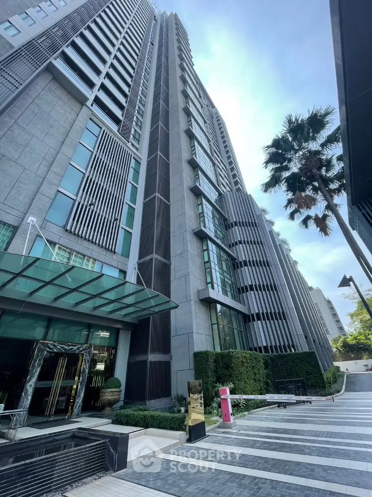 Stunning modern high-rise building with sleek architecture and lush landscaping in urban setting.