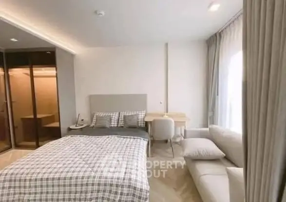 Modern bedroom with stylish decor, featuring a cozy bed, elegant desk, and ample natural light.