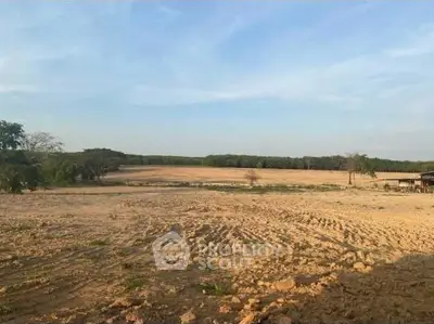 Expansive land plot with clear skies, ideal for development or agriculture.