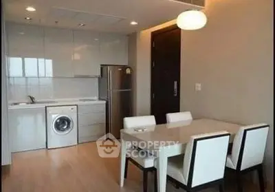 Modern kitchen and dining area with sleek appliances and elegant dining set.