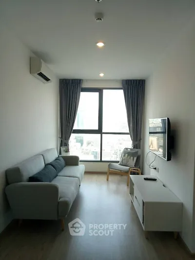 Modern living room with large window and city view, featuring a cozy sofa and wall-mounted TV.