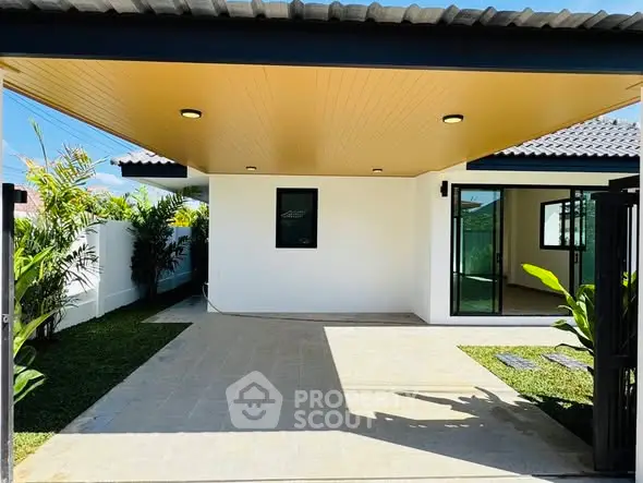 Modern single-story home with spacious carport and lush garden