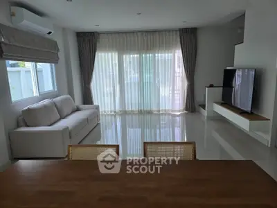 Spacious modern living room with large windows and elegant furnishings