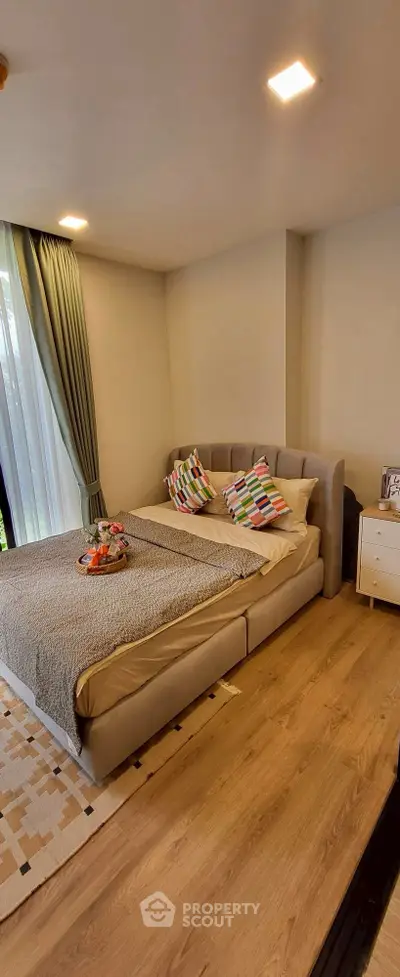 Cozy bedroom with stylish decor and natural light, featuring a comfortable bed and elegant curtains.