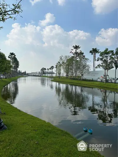 Serene canal view with lush greenery and palm trees, perfect for tranquil living.