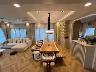 Luxurious open-plan living and dining area with elegant wooden table and modern decor.