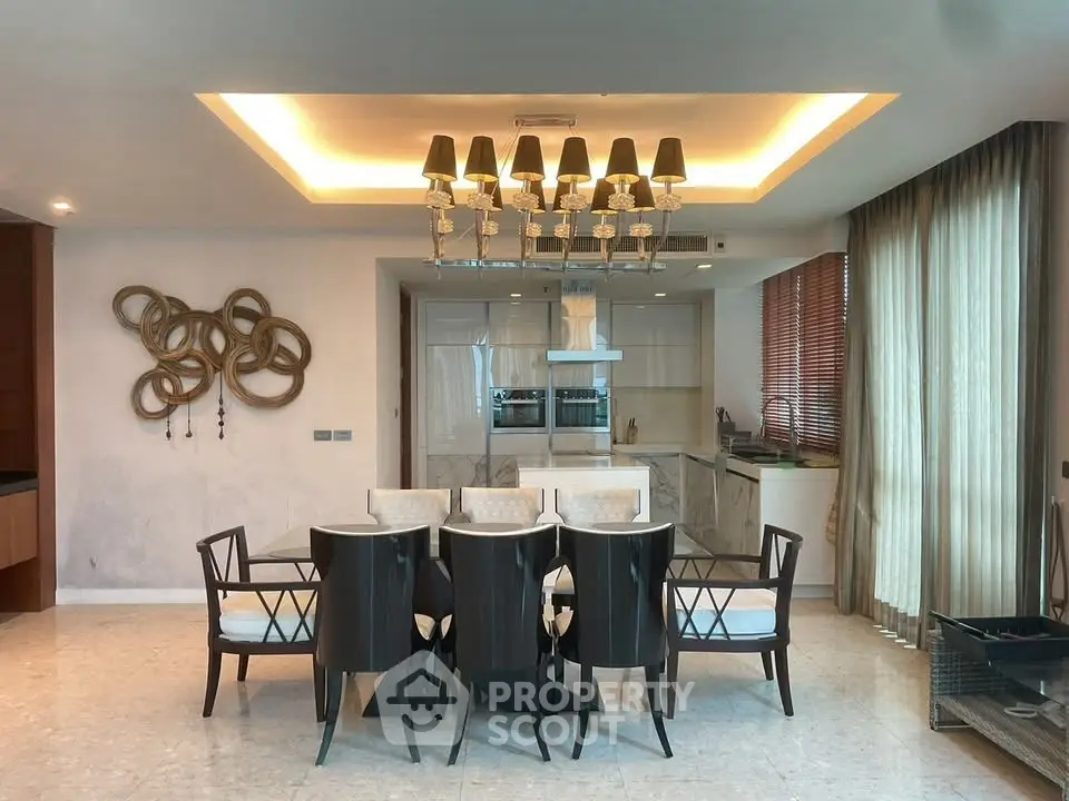 Elegant dining area with modern chandelier and open kitchen layout in luxury apartment.