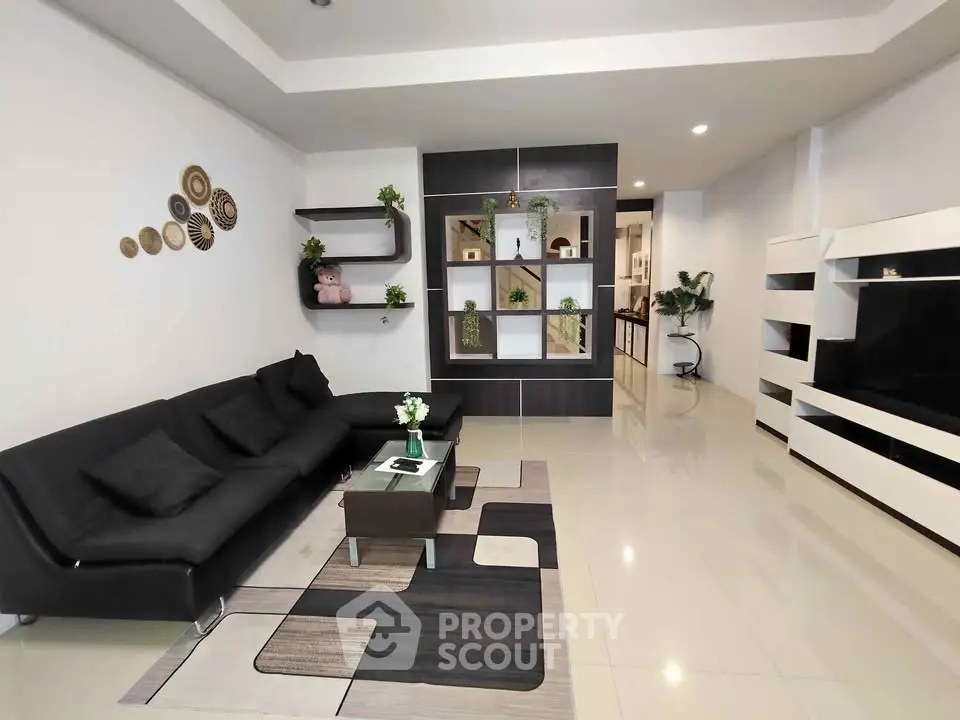 Spacious modern living room with sleek black sofa and stylish decor