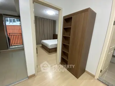 Spacious bedroom with wooden flooring and balcony access in modern apartment