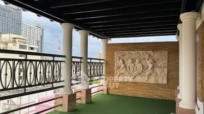 Spacious balcony with decorative wall art and city view, perfect for relaxation and entertaining.