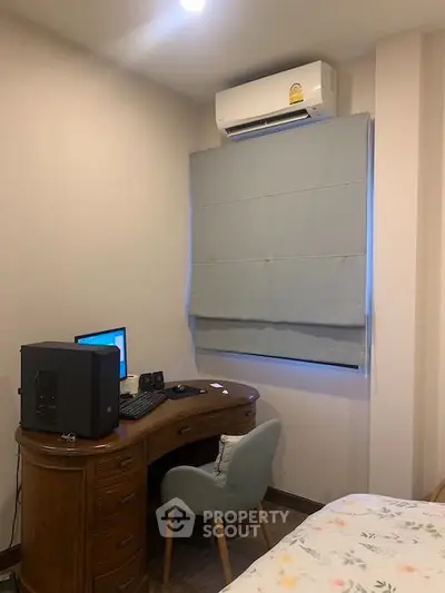 Cozy study room with desk, chair, and air conditioning, perfect for home office setup.