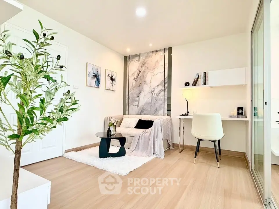 Modern living room with stylish decor and cozy workspace in a bright apartment.