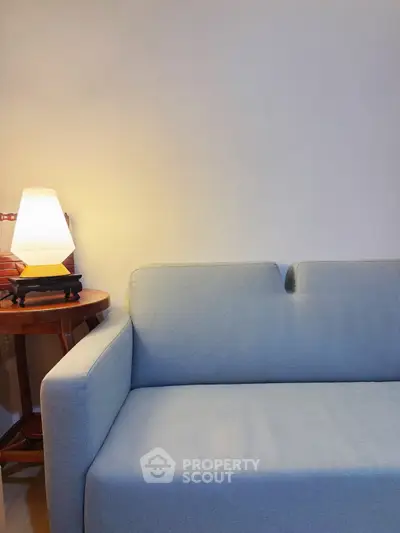 Cozy living room with stylish sofa and elegant lamp on side table.