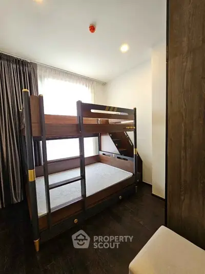Modern bedroom with stylish bunk bed and elegant curtains, perfect for maximizing space and comfort.