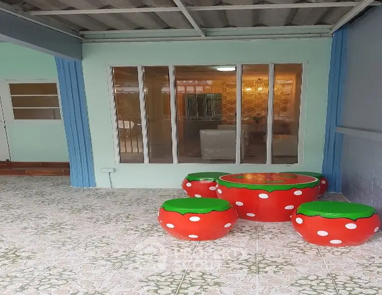 Charming patio with unique mushroom-themed seating and glass doors leading to a cozy interior.