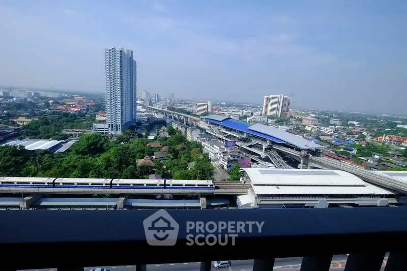 Stunning cityscape view from high-rise balcony overlooking urban skyline and transit lines.