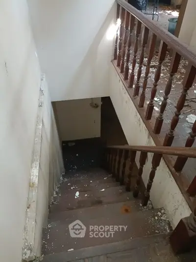 Rustic staircase in need of renovation with wooden railings and peeling paint