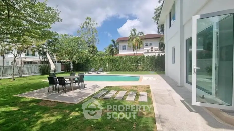 Luxurious backyard with private pool and lush garden in upscale neighborhood.