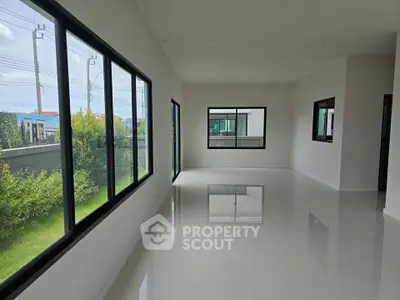 Spacious unfurnished living room with large windows and garden view