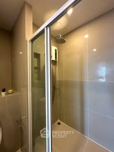 Modern bathroom with sleek shower enclosure and neutral tiles