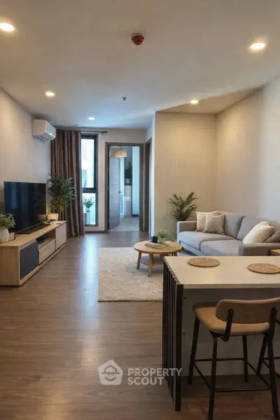 Modern living room with stylish decor and open layout, featuring a cozy sofa and entertainment center.