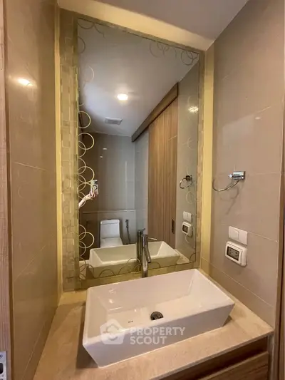 Modern bathroom with elegant sink and large mirror in a stylish apartment.
