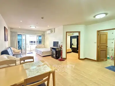Spacious open-plan living area with modern furnishings and balcony access