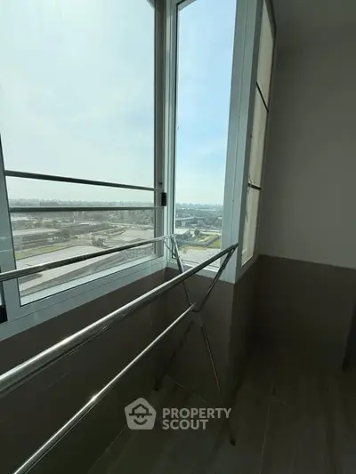 Bright balcony with expansive city view and sleek drying rack, perfect for urban living.