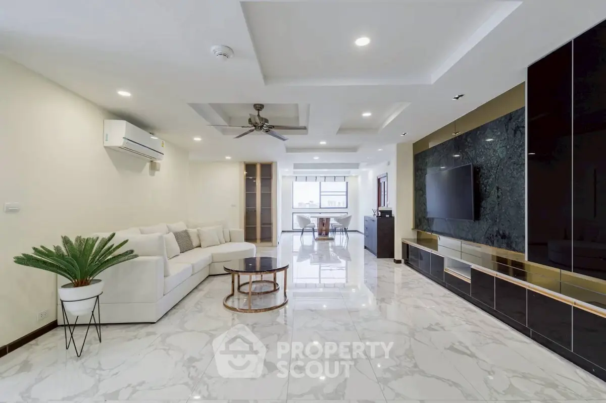 Spacious modern living room with marble flooring and sleek entertainment unit.