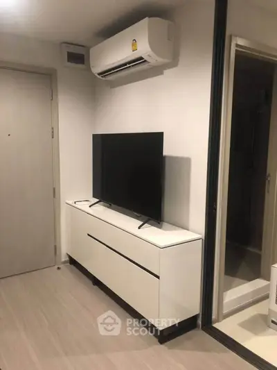 Modern living room with sleek TV stand and air conditioning unit, perfect for comfortable urban living.