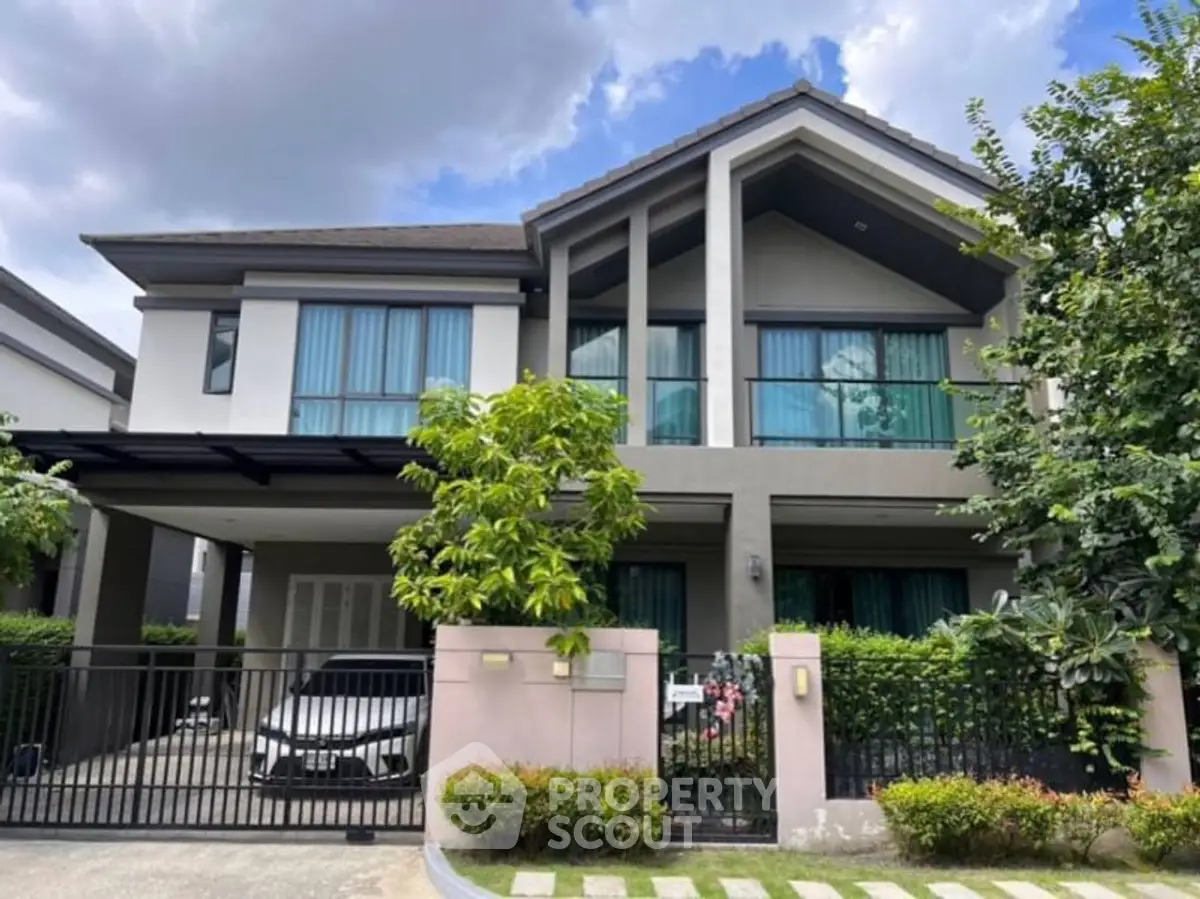 Stunning modern two-story house with lush greenery and spacious driveway.