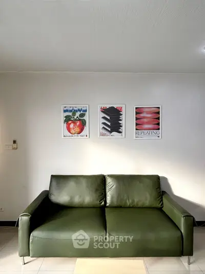 Modern living room with stylish green sofa and artistic wall decor