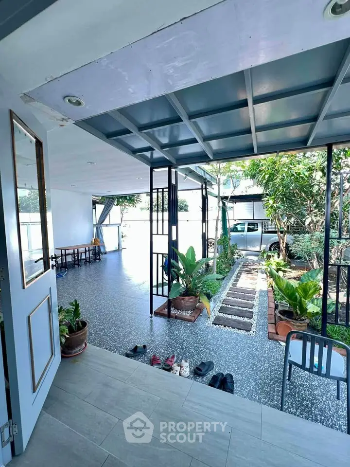Spacious covered patio with garden view and modern design, perfect for relaxation and outdoor gatherings.