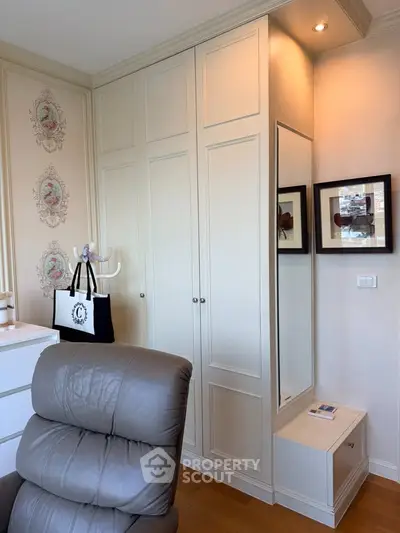Elegant study room with built-in wardrobe and leather chair, perfect for a home office setup.