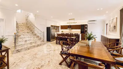 Luxurious open-plan living and dining area with elegant staircase and modern kitchen.