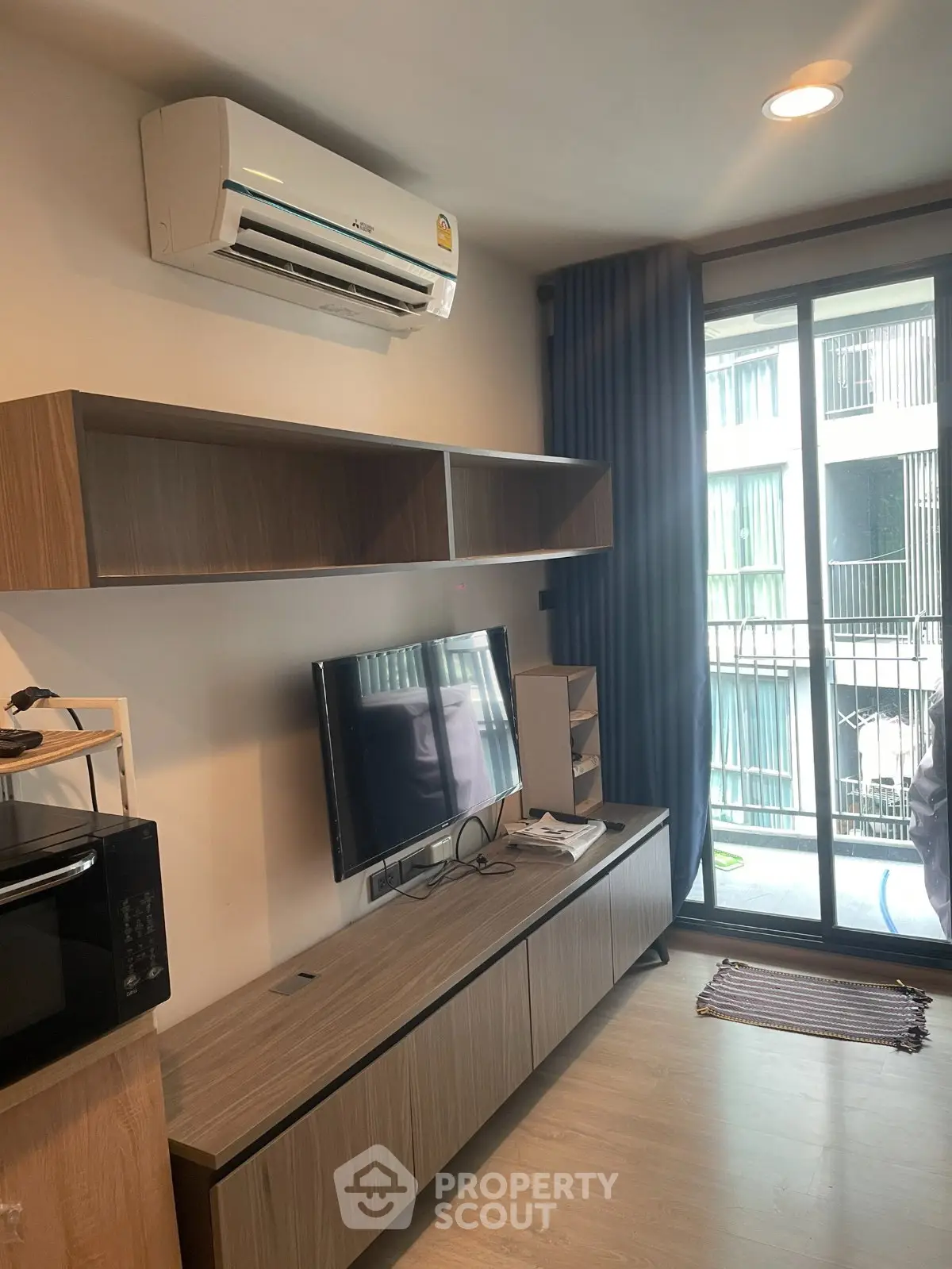 Modern living room with air conditioning and balcony view in a stylish apartment.