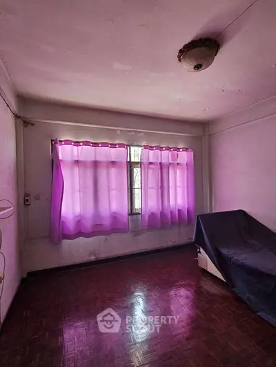 Cozy room with purple curtains and wooden flooring, ideal for creative renovation.