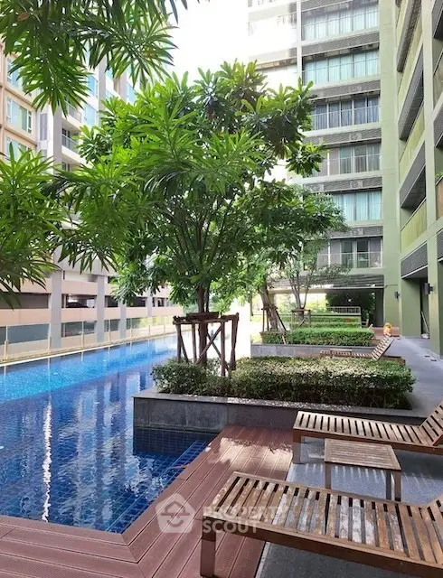 Luxurious condominium pool area with lush greenery and modern design.