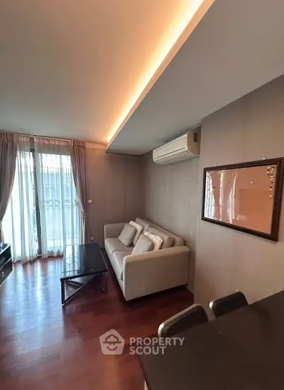 Modern living room with cozy sofa and stylish decor, featuring natural light and elegant wooden flooring.