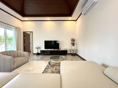 Spacious living room with modern furniture and air conditioning, featuring elegant decor and natural light.