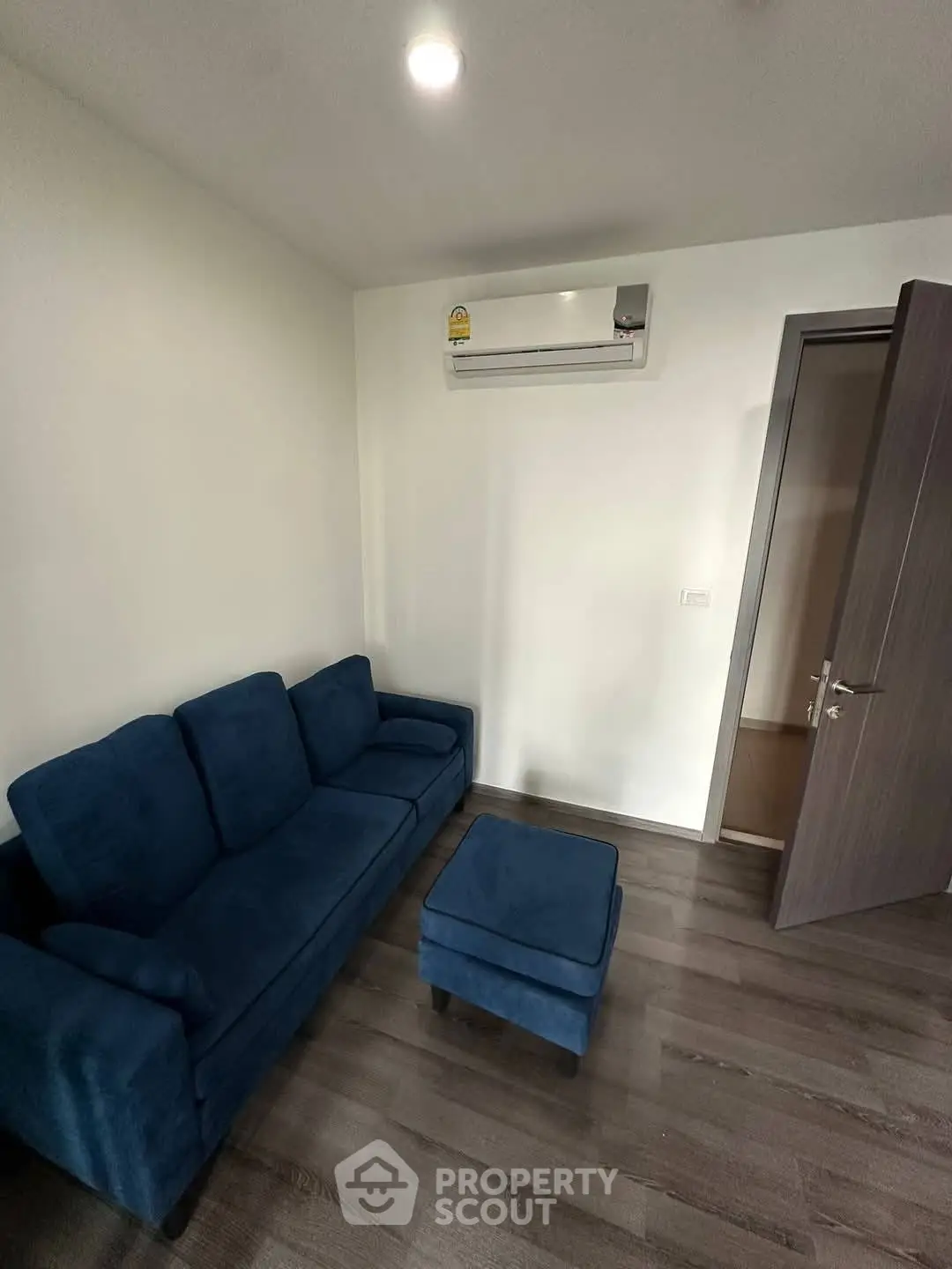 Cozy living room with blue sofa and air conditioning, perfect for relaxation.