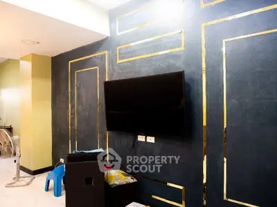 Modern living room with stylish accent wall and mounted TV, perfect for entertainment.