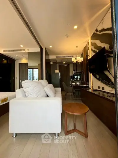 Modern living room with sleek design and open layout, featuring a cozy sofa and stylish decor.