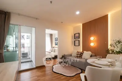 Modern open-plan living room with cozy decor and balcony access in a stylish apartment.